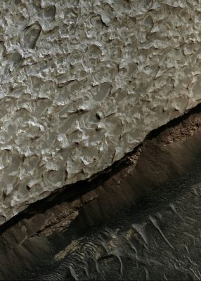 Features and Mineralogy of Aram Chaos (extra-detail mgnf - MULTISPECTRUM; credits: Lunexit)
In this extra-detail mgnf, the lighter-toned area is a heavily fluted and pitted Capping Unit. This surface tends to trap dark sand in the lows. 
The dark sand can also be seen to form dunes below the cliff.

Sulfates have been detected in the cliff walls in some areas within Aram Chaos, as well as Hematite. It has been suggested that these materials were deposited within a lake setting.
Parole chiave: Mars from orbit - Aram Chaos Region