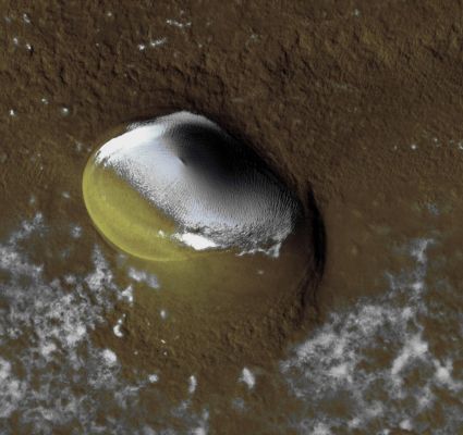 Small Crater on the North Polar Layered Deposits (EDM - Enhanced Natural Colors; credits for the additional process. and color.: Dr Paolo C. Fienga - Lunexit Team) 
This crater proved to be a surprise in a few ways. Its shape is non-circular which is quite unusual for an impact crater. One possibility is that flow of the ice beneath the surrounding terrain has deformed the crater; however, ice-flow rates are thought to be very low on Mars today. 

The crater also contains a patch of bright ice despite being surrounded by terrain that has mostly lost its ice cover. This seems typical for these polar craters and it may be that ice within these craters is protected from ablation by shading from the crater walls.
Parole chiave: Mars from orbit - North Polar Features - NPLD