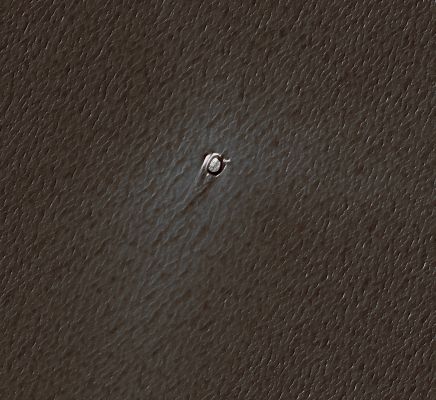 Small and young Impact Crater in the NPLD (edm - natural colors; credits: Lunexit)
The Impact Crater is about 66 meters (215 feet) in diameter. Ejecta from this Crater can be seen extending primarily to the North-West. 
The asymmetry in the crater ejecta can be an effect of atmospheric winds associated with the impact itself but, in this case, is most likely the result of an oblique impact (a low impact angle with respect to the horizontal). 
As impact angles decrease, the ejecta blanket is increasingly offset downrange.

The impactor that formed this crater approached the surface from the South-East. The slightly elliptical shape of the crater is also a result of an oblique impact.
Parole chiave: Mars from orbit - Craters - Unnamed Crater in the NPLD