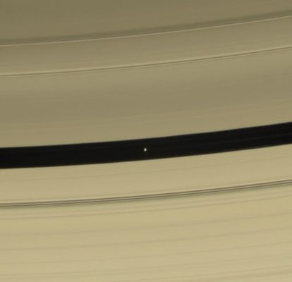 Pan
Caption NASA:"Pan is seen in this color view as it sweeps through the Encke Gap with its attendant ringlets. As the lemon-shaped little moon orbits Saturn, it always keeps its long axis pointed along a line toward the Planet. From this vantage point, the dark side of the moon is visible. 
This view looks toward Pan (26 Km or 16 miles across) within the Encke Gap (325 Km or 200 miles wide), on the unlit side of the Rings, and from an inclination of about 33° above the Ring-Plane. 

Images taken using red, green and blue spectral filters were combined to create this natural color view. The image was taken with the Cassini spacecraft narrow-angle camera on Dec. 16, 2006 at a distance of approx. 779.000 Km (about 484.000 miles) from Pan and at a Sun-Pan-spacecraft, or phase angle of 83°. 

Image scale is roughly 5 Km (a little more than 3 miles) per pixel".
Parole chiave: Saturn's Moons - Pan