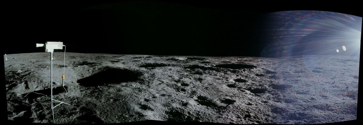 From AS 12-46-6756 until 6761 (EVA-1; The TV Camera)
116:24:47 MT - Rightway of 6755. Close-up of the TV camera, with the Solar Wind Collector (SWC) at the left edge of the picture. Note the loop in the TV cable running off to the left.
Paul Coan, Manned Spaceflight Center Television Subsystem Manager who was responsible for the equipment used on the Apollo spacecraft, writes, "The same type of cable used to carry video and power between the Apollo 11 TV camera and the LM was used during Apollo 12 to power the first color TV camera to be put on the Lunar Surface. 
However, the connector on the color camera did not match the connector on the end of the Lunar Surface cable that was an integral part of the camera handle. (See a detail from Apollo 11 photo S-69-31575 ). Since the design and qualification of the Lunar Surface cable was so expensive, it was cost prohibitive to replace the connector on the cable. Cost, schedule, and design constraints also precluded replacing the connector on the color camera. 
So, we decided to build an adapter that provided the interconnection."

In a detail from 6756, the color-camera camera hangs down from the back, with the yellow-coated adapter immediately blow attached to the silver-tube of the 'handle' from the Apollo 11 configuration.

Coan adds, "During testing of the color Lunar Camera connected to the LM on the pad at KSC, we noticed hum bars in the video. 
We then realized that the finite resistance of the power circuit in the 100 foot Lunar Camera cable combined with the switching power supply in the camera was sufficient to inject the hum bars in the video. We had to rework the power supply circuits to eliminate the hum bars. There was some quick redesign/rework done to make the camera work."
"Finally, there was a special room provided at KSC for final checkout of the cameras before they were installed in the spacecraft. So that we could test under controlled lighting conditions, the room was painted totally black and provided with heavy window curtains to eliminate light from outside".
Parole chiave: Lunar Panorama - Landing Site