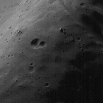 High-Resolution MOC Image of Phobos' Face
This image of Phobos, the inner and larger of the two moons of Mars, was taken by the Mars Global Surveyor on August 19, 1998. The minimum distance between the Spacecraft and Phobos was 1080 Km (about 671 miles). 
Phobos was observed by both the Mars Orbiter Camera (MOC) and Thermal Emission Spectrometer (TES). This image is one of the highest resolution images (4 meters or 13 feet per picture element or pixel) ever obtained of the Martian satellite. 

The image shows several new features of this lumpy moon -- features that are associated with the prominent crater seen in the upper left quarter of the image. This is the largest crater on Phobos, Stickney, 10 Km (about 6 miles) in diameter. Individual boulders are visible on the near rim of the crater (D), and are presumed to be ejecta blocks from the impact that formed Stickney. Some of these boulders are enormous - more than 50 meters (160 feet) across. 

Also crossing at and near the rim of Stickney are shallow, elongated depressions called grooves. This crater is nearly half the size of Phobos and these grooves may be fractures caused by its formation. The far wall of the crater shows lighter and darker streaks going down the slopes (C). The presence of material of different brightness on the far crater slopes and in some of the grooves shows that the satellite is heterogeneous (that is, it is made of a mixture of different types of materials). The motion of debris down slopes is guided by gravity, which is only about 1/1000th that of the Earth -- e.g., a 68-Kg (150- pound) person would weigh only about 57 gr (2 ounces) on Phobos. 

Previous images from the Viking Spacecraft in the 1970's were not of sufficient resolution to show the effectiveness of gravity on Phobos in moving material down slopes.
Parole chiave: Phobos