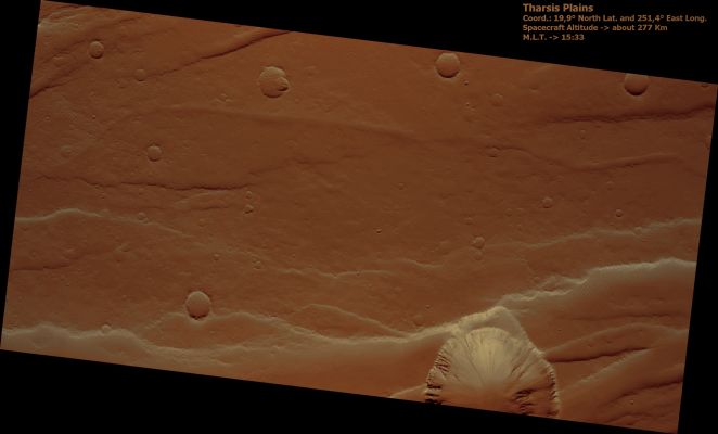Tharsis' Plains (natural colors; credits: Lunar Explorer Italia)
This HiRISE image samples the plains between the large shelf volcanoes in the Tharsis Region of Mars. 
The long scarps in the area have been formed by faults as the ground was pulled apart. The large circular depression on the edge of the image is a giant collapse pit that appears to be related to the opening up of crust.

If you look at this image carefully, much of the plains appears blurry, as if the picture was out of focus. But HiRISE remains in perfect focus and it is Mars that is actually this blurry. Soft wind-blown dust mutes all the features in the area to create this effect.
