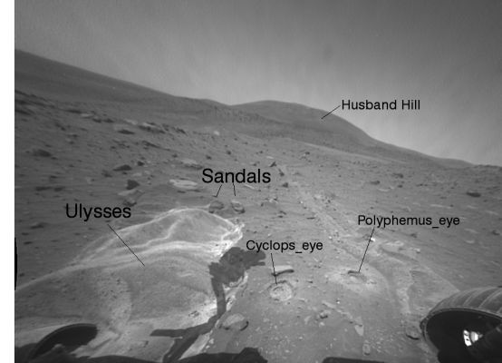 The Ancient Greece on Mars... - Sol 1998
This image taken by the Front HazCam on NASA's MER Spirit looks toward the North/West and shows some of the targets examined by Spirit after the Rover became embedded at this site. 

"Ulysses" is the area where Spirit's left wheels broke through a crust and stirred up poorly sorted, weakly cohesive sands. 
"Sandals" are two small rocks to the North/West of Ulysses. 
"Cyclops Eye" and "Polyphemus Eye" are two locations in which Spirit's RAT (Rock Abrasion Tool) was used to bore into the subsurface for detailed textural, compositional and mineralogical measurements. 

Ulysses has the highest Sulfate content measured by either Spirit or Opportunity. 
Cyclops Eye also has sulfate minerals beneath the surface whereas Polyphemus Eye does not. 
Thus Spirit must be sitting over a geologic boundary where materials are different to the West as opposed to the East.
Parole chiave: Mars Panorama - Gusev Crater - Husband Hill