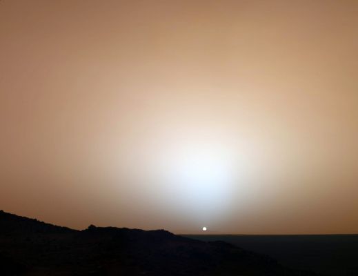 Sunset on Mars... - Sol 489 (strongly enhanced Natural Colors; credits: NASA/JPL/Texas A&M/Cornell)
Caption NASA:"On May 19th, 2005, NASA's Mars Exploration Rover Spirit captured this stunning view as the Sun sank below the Rim of Gusev Crater on Mars. 
This Panoramic Camera (PanCam) mosaic was taken around 18:07 in the evening of the Rover's 489th Sol. Spirit was commanded to stay awake briefly after sending that Sol's data to the Mars Odyssey Orbiter just before Sunset. This small panorama of the western sky was obtained using PanCam's 750-nanometer, 530-nanometer and 430-nanometer color filters. This filter combination allows false color images to be generated that are similar to what a human would see, but with the colors slightly exaggerated. 
In this image, the bluish glow in the sky above the Sun would be visible to us if we were there, but an artifact of the PanCam's infrared imaging capabilities is that with this filter combination the redness of the sky farther from the Sunset is exaggerated compared to the daytime colors of the Martian Sky. 
Because Mars is farther from the Sun than the Earth is, the Sun appears only about two-thirds the size that it appears in a Sunset seen from the Earth. The terrain in the foreground is the rock outcrop "Jibsheet", a feature that Spirit has been investigating for several weeks (Rover Tracks are dimly visible leading up to "Jibsheet"). 
The floor of Gusev Crater is visible in the distance, and the Sun is setting behind the wall of Gusev some 80 Km (about 50 miles) in the distance. 

This mosaic is yet another example from MER of a beautiful, sublime martian scene that also captures some important scientific information. Specifically, sunset and twilight images are occasionally acquired by the science team to determine how high into the Atmosphere the Martian Dust extends, and to look for dust or ice clouds. 
Other images have shown that the twilight glow remains visible, but increasingly fainter, for up to two hours before Sunrise or after Sunset. The long Martian Twilight (compared to Earth's) is caused by Sunlight scattered around to the night side of the Planet by abundant high altitude dust. 
Similar long twilights or extra-colorful sunrises and sunsets sometimes occur on Earth when tiny dust grains that are erupted from powerful volcanoes scatter light high in the Atmosphere".

Note Lunexit: la NASA, in questa caption, ci dice che il Sole, dalla Superficie di Marte, dovrebbe apparire con un diametro apparente pari a circa i 2/3 del diametro apparente che esso ci mostra dalla Terra. 
Curioso: sino a poco tempo fa, l'informazione NASA ufficiale era che il diametro apparente del Sole, dalla Superficie Marziana, era di 2/3 più piccolo rispetto al suo diametro apparente percepibile da Terra e quindi doveva essere pari ad 1/3 di quest'ultimo.
La differenza, come ovvio, non è piccola e le implicazioni - particolarmente quelle connesse alla luminosità dell'ambiente marziano - sono piuttosto importanti.
Lo ammettiamo: siamo un pò confusi a questo punto ma, forse, possiamo risolvere il dubbio noi stessi: abbiate solo un pizzico di pazienza...
Parole chiave: Postcard from Mars - Sunset