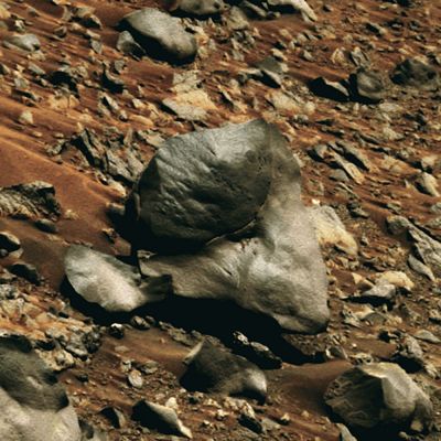 Something's wrong with that boulder... - Sol 658 (natural colors + MULTISPECTRUM; credits: Dr G. Barca & Lunexit)
Un macigno davvero indecifrabile, quello che appare in primo piano in questo frame... Osservate bene: una sorta di "lingua" di roccia (tanto sottile ed arcuata, quanto impossibile, se quella che stiamo osservando è realmente una pietra...) si alza dalla sua base (in basso a Sx dell'Osservatore) per raggiungere circa la metà dell'altezza del boulder. E non è certo finita qui!

Se infatti osservate alla Vostra Dx, in basso, Vi accorgerete che il macigno NON poggia completamente al suolo, e sembra (SEMBRA!) giacere in equilibrio instabile.

Ma il clou, a nostro avviso, è la frattura latitudinale che lo attraversa e divide, andando da ore 08:00 ad ore 12:00. Una leggera differenza di colorazione, ma NON di texture, distingue la porzione fratturata Dx del boulder (Sx dell'Osservatore - più scura), da quella Sx (Dx dell'Osservatore - più chiara).

Molto "curioso" (diciamo così...) è, infine, il frammento di roccia che si trova a Dx della porzione più grande del macigno (Sx dell'Osservatore) il quale - forse - formava una sorta di appendice, ora semi-distaccata, del macigno stesso.

Sensazione: l'esistenza di incoerenze nella riflessione della luce da parte delle diverse componenti del boulder in esame, unita alla difficile spiegazione (in termini prospettici) dei detriti che si trovano immediatamente "dietro" al macigno - tutto questo senza stare a rimenzionare nè la "crepa" latitudinale (nettissima e profonda) che, letteralmente, lo dovrebbe "spaccare in due", nè l'equilibrio improprio su cui giace tutto il complesso -, ci portano a ritenere che questa immagine POTREBBE essere un falso (o, al limite, il risultato di un additional processing altamente invasivo il quale era volto a censurare la porzione di frame che, oggi, è costituita dalla parte del boulder a Sx dell'Osservatore).

I Vostri commenti saranno apprezzati.
Parole chiave: Martian Surface - Boulders - Possible Tampering