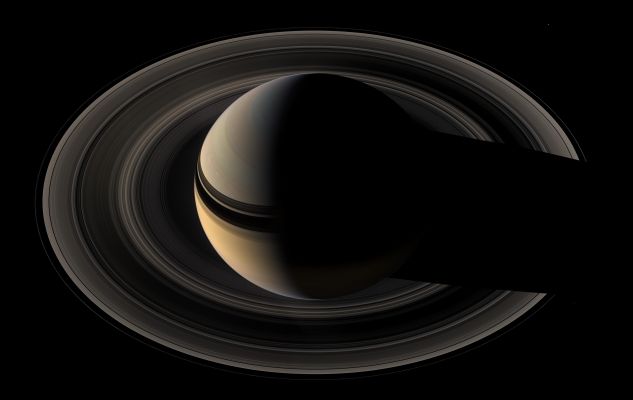 Looking at the Giant
Saturn sits nested in its rings of ice as Cassini once again plunges toward the graceful giant. This natural color mosaic was acquired by the Cassini spacecraft as it soared 39° above the unilluminated side of the Rings. 
Little light makes its way through the Rings to be scattered in Cassini's direction in this viewing geometry, making the Rings appear somewhat dark compared to the reflective Planet. The view can be contrasted with earlier mosaics designed to showcase the Rings rather than the Planet, which were therefore given longer exposure times.
Bright clouds play in the blue-gray skies of the North. The Ring shadows continue to caress the Planet as they slide farther South toward their momentary disappearance during Equinox in 2009. 
The Rings' reflected light illuminates the Southern Hemisphere on Saturn's night side.
The scene is reminiscent of the parting glance of NASA's Voyager 1 as it said goodbye to Saturn in 1981 (see PIA00335). Cassini, however, will continue to orbit Saturn for many years to come. 

Three of Saturn's moons are visible in this image: Mimas (about 397 Km across) at the 2 o'clock position, Janus (about 181 Km across) at the 4 o'clock position and Pandora (about 84 Km across) at the 8 o'clock position. Pandora is a faint speck just outside the narrow F-Ring. 
This mosaic was constructed from wide-angle camera images taken just before the narrow-angle camera mosaic PIA08389. 
The view combines 45 images -- 15 separate sets of red, green and blue images -- taken over the course of about two hours, as Cassini scanned across the entire Main Ring System. 
The images in this view were obtained on May 9, 2007, at a distance of approx. 1,1 MKM (about 700.000 miles) from Saturn. 
Image scale is about 62 Km (approx. 39 miles) per pixel. 
Parole chiave: Saturn