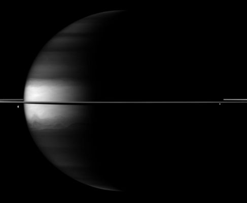 Out of the Darkness...
Caption NASA:"Dramatic differences between dark and light embellish this Cassini Spacecraft image of Saturn, its rings and its moons Dione and Enceladus. 

Saturn's Northern and Southern Latitudes appear dark in this image because of the camera filter used. This view uses a spectral filter sensitive to absorption of certain wavelengths of light by Methane in Saturn's Atmosphere. The cloud tops in the Northern and Southern Latitudes are at a slightly greater depth than in the Equatorial Region, and are underneath a layer of Methane. This means that light travels along a longer path compared to the Equatorial Region as it enters the Atmosphere, reflects off the cloud tops, and returns through the Upper Atmosphere to enter the camera. 

The light at Near-InfraRed wavelengths thus passes through more light-absorbing Methane at the Northern and Southern Latitudes than at the Equator, and so these Latitudes appear darker. 
Dione (approx 1123 Km, or about 698 miles across) can be seen on the left of the image. Enceladus (approx. 504 Km, or about 313 miles across) is visible on the right. 
This view looks toward the Northern, sunlit side of the Rings from just above the Ring-Plane. 

The image was taken with the Cassini Spacecraft wide-angle camera on Oct. 21, 2009 using a spectral filter sensitive to wavelengths of Near-InfraRed Light centered at 890 nanometers. The view was obtained at a distance of approx. 2,5 MKM (such as about 1,6 MMs) from Saturn and at a Sun-Saturn-Spacecraft, or Phase, Angle of 104°. 
Image scale is roughly 143 KM (such as about 89 miles) per pixel".
Parole chiave: Saturn with Dione and Enceladus