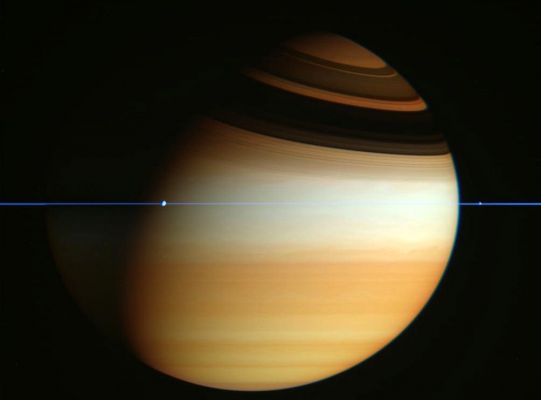 Along the Ring-Plane of Saturn (natural colors; credits: NASA)
Caption NASA originale:"When Saturn's appendages disappeared in 1612, Galileo did not understand why. Later that century, it became understood that Saturn's unusual protrusions were Rings and that when the Earth crosses the Ring-Plane, the edge-on rings will appear to disappear. 
This is because Saturn's Rings are confined to a plane many times thinner, in proportion, than a razor blade. In modern times, the Cassini Spacecraft orbiting Saturn now also crosses Saturn's Ring-Plane. A series of plane crossing images from late February (2006) was dug out of the vast online Cassini raw image archive by interested Spanish amateur Fernando Garcia Navarro. 

Pictured above, digitally cropped and set in representative colors, is the striking result. Saturn's thin Ring-Plane appears in blue, bands and clouds in Saturn's Upper Atmosphere appear in gold and dark shadows of the Rings curve across the top of the Gas Giant Planet. Moons appear as bumps in the Rings". 
Parole chiave: Saturn and others Moons