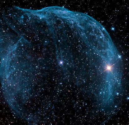 Sharpless 308
Caption NASA:"Blown by fast winds from a hot, massive star, this cosmic bubble is huge. Cataloged as Sharpless 308 it lies some 5200 LY away in the constellation Canis Major and covers over 2/3° on the sky (compared with 0,5° for the Full Moon). That corresponds to a diameter of 60 LY at its estimated distance. The massive star itself, a Wolf-Rayet Star, is the bright blue one near the center of the Nebula. 
Wolf-Rayet Stars have over 20 times the mass of the Sun and are thought to be in a brief, pre-supernova phase of massive star evolution. Fast winds from this Wolf-Rayet Star create the bubble-shaped nebula as they sweep up slower moving material from an earlier phase of evolution. 
The windblown nebula has an age of about 70.000 years. Relatively faint emission captured in the expansive image is dominated by the glow of Ionized Oxygen atoms mapped to bluish hues".
Parole chiave: From Earth Pictures - Professional Pictures