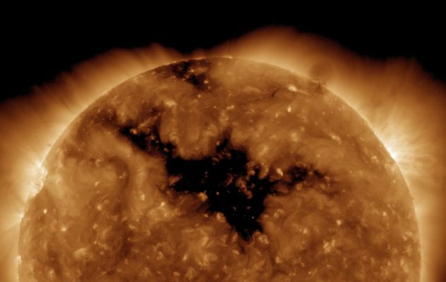 Deep Coronal Holes
Caption NASA:"This ominous, dark shape sprawling across the face of the Sun is a Coronal Hole -- a low density region extending above the Surface where the Solar Magnetic Field opens freely into interplanetary space. 
Studied extensively from space since the 1960s in UltraViolet and X-Ray Light, Coronal Holes are known to be the source of the high-speed Solar Wind (such as atoms and electrons which flow outward along the open Magnetic Field lines). During periods of low activity, Coronal Holes typically cover regions just above the Sun's Poles. 
But this extensive Coronal Hole dominated the Sun's Northern Hemisphere earlier this week, captured here in Extreme UV Light by cameras onboard the Solar Dynamics Observatory. The solar wind streaming from this Coronal Hole triggered auroral displays on Earth".
Parole chiave: From Space Pictures