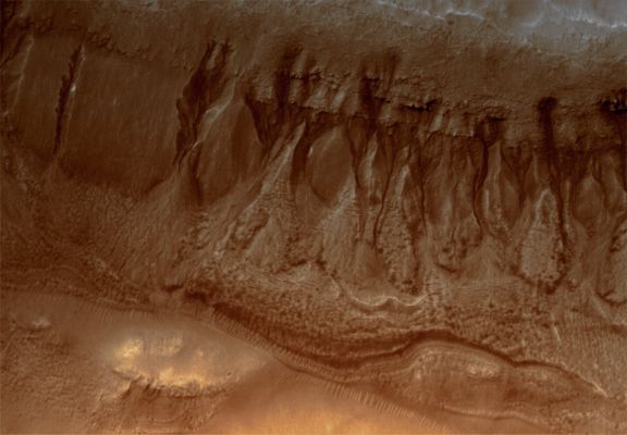 Gullies in Terra Cimmeria (Natural Colors; credits for the additional process. and color.: Dr Paolo C. Fienga - Lunar Explorer Italia)
Caption originale NASA:"This MGS-MOC image shows two suites of gullies within a single impact crater in the Terra Cimmeria Region. The gullies near the top of the image are located on the northern wall of the crater, while the lower suite resides on a lower bench in the crater's northern wall complex. Gully erosion has cut into the layered rock exposed on the crater wall. Water may have been involved in their formation". 

Location near: 38,2° South; 190,6° West
Image width: ~3 Km (~1,9 mi) 
Illumination from: upper left 
Season: Southern Summer
Parole chiave: Mars from orbit - Gullies - Terra Cimmeria Region