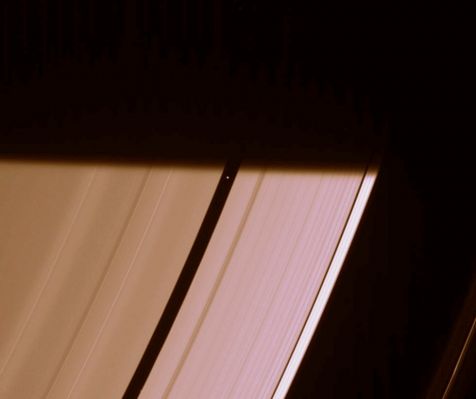 Some in the Darkness, some in the Light...
Caption NASA:"Pan prepares to be engulfed by the darkness of Saturn's shadow, visible here as it stretches across the Rings. 
When the Cassini spacecraft took a follow-up image of this same location about 50 seconds later, Pan (26 kilometers, or 16 miles across) had vanished into darkness. 
This view looks toward the unilluminated side of the Rings from about 44° above the Ring-Plane. 

The image was taken in visible light with the Cassini spacecraft narrow-angle camera on March 14, 2007 at a distance of approx. 1,9 MKM (about 1,2 MMs) from Pan. Image scale is roughly 11 Km (about 7 miles) per pixel".
Parole chiave: Saturn's Rings