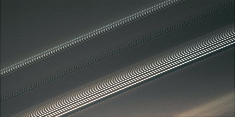 The A-Ring in 16:9 (natural colors + MULTISPECTRUM; credits: Lunexit)
Caption NASA:"Spiral density waves in Saturn's A-Ring reveal the gravitational signatures of distant moons as they subtly tug on the countless particles orbiting in the Ring-Plane. 
Resulting from a process called orbital resonance, a spiral density wave is a spiral-shaped massing of particles that tightly winds many times around the Planet. Thus, the wave patterns seen here represent successive windings of each wave, like a close-up view of a watch spring. 
Ring scientists can read these patterns, learning from them how quickly the Rings are spreading and the amount of mass contained in a region. 

This view looks toward the sunlit side of the Rings from about 42° below the Ring-Plane. The image was taken in visible light with the Cassini spacecraft narrow-angle camera on April 1, 2008. The view was obtained at a distance of approx. 268.000 Km (about 167.000 miles) from Saturn. 
Image scale is roughly 1 Km (0,6 miles) per pixel".
Parole chiave: Saturn's Rings