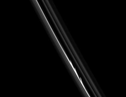 Gravitational Interactions or just Evidence of a recent Collision?
Caption NASA:"The three bright, finger-like jets of material seen here suggest that a small object has collided with the core of Saturn's F-Ring. Cassini Spacecraft imaging scientists have shown that the F-Ring shepherd moon Prometheus influences the structure of the Ring in 2 ways: 1) by creating streamer-channel features as it closely approaches (and partially passes into) the Ring (see PIA08397) and 2) by perturbing the orbits of small objects within the F-Ring Region which then exert their own influence on nearby Ring particles, as seen here. 
These small, embedded objects could be temporary clumps of particles, but scientists think at least one of the objects could be a more permanent moonlet. 

This view looks toward the sunlit side of the Rings from about 40° below the Ring-Plane. The image was taken in visible light with the Cassini Spacecraft narrow-angle camera on Aug. 20, 2008. The view was obtained at a distance of approx. 685.000 Km (such as about 426.000 miles) from Saturn and at a Phase Angle of 40°.
The image scale is about 5 Km per pixel".
Parole chiave: Saturn's Rings - The "F-Ring"