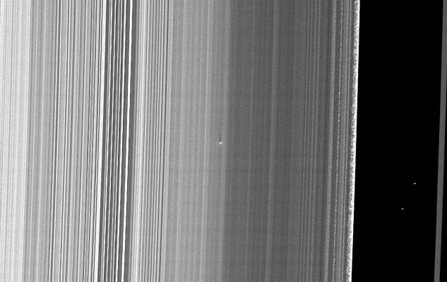 Small Object in the "B"-Ring
Caption NASA:"The Cassini Spacecraft captured this image of a small object in the outer portion of Saturn's "B"-Ring casting a shadow on the Rings as Saturn approaches its August 2009 Equinox. 

This new moonlet, situated about 300 miles (approx. 480 Km), inward from the outer edge of the "B"-Ring, was found by detection of its shadow which stretches 25 miles, or about 41 Km, across the Rings. 
The shadow length implies the moonlet is protruding about 660 feet, or 200 meters, above the Ring-Plane. 
If the moonlet is orbiting in the same plane as the ring material surrounding it, which is likely, it must be about 1300 feet, or 400 meters, across. 

This object is not attended by a Propeller feature, unlike the band of moonlets discovered in Saturn's "A"-Ring earlier by Cassini (see PIA07792 and PIA06196). The "A"-Ring moonlets, which have not been directly imaged, were found because of the propeller-like narrow gaps on either side of them that they create as they orbit within the Rings. The lack of a propeller feature surrounding the new moonlet is likely because the "B"-Ring is dense, and the ring material in a dense ring would be expected to fill in any gaps around the moonlet more quickly than in a less dense region like the mid-"A"-Ring. Also, it may simply be harder in the first place for a moonlet to create propeller-like gaps in a dense ring. 

Straw-like patterns of clumping ring material are also visible along the edge of the outer "B"-Ring near the right of this image. See PIA09855 to learn more about these features. 

This image and others like it (see PIA11656 and PIA11659) are only possible around the time of Saturn's Equinox which occurs every half-Saturn-year (equivalent to about 15 Earth years). The illumination geometry that accompanies Equinox lowers the Sun's angle to the Ring-Plane and causes out-of-plane structures to cast long shadows across the Rings. 
This view looks toward the sunlit side of the Rings from about 42° below the Ring-Plane. Background stars are visible on the right of the image. They appear elongated by the camera's exposure time. 

The image was taken in Visible Light with the Cassini Spacecraft narrow-angle camera on July 26, 2009. The view was obtained at a distance of approx. 296.000 Km (such as about 184.000 miles) from Saturn and at a Sun-Saturn-Spacecraft, or Phase, Angle of 120°. 
Image scale is roughly 1 Km (4680 feet) per pixel".
Parole chiave: Saturn's Rings - "B" Ring