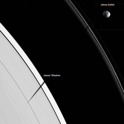 Janus and its Shadow on the Rings
Caption NASA: (Main Frame) "The Cassini Spacecraft catches Janus joining other Saturnian moons in the Equinox "shadow-casting" party. As Saturn approaches its August 2009 Equinox, the Planet's moons cast shadows onto the Rings. Janus (about 179 Km, or approx. 111 miles across) is not visible in this image it has been added in the inset on upper right), but its shadow stretches across Saturn's A and F-Rings. Three background stars are visible in the image. 

This view looks toward the sunlit side of the Rings from about 21° below the Ring-Plane. The image was taken in vVisible Light with the Cassini Spacecraft narrow-angle camera on May 10, 2009. The view was acquired at a distance of approx. 965.000 kM (such as about 600.000 miles) from Saturn and at a Phase Angle of 46°. 
Image scale is roughly 5 Km (a little more than 3 miles) per pixel".

(Inset): "The small moon Janus is illuminated by light from both the Sun and Saturn. This view looks toward the South Pole of Janus which lies on the Terminator, just below the center of the image. Brightly lit terrain seen on the right is on the Leading Hemisphere of Janus. Light reflected off Saturn dimly lights the Saturn-facing side of Janus on the top left of the image. 

The image was taken in Visible Light with the Cassini Spacecraft narrow-angle camera on May 9, 2009. The view was acquired at a distance of approx. 974.000 Km (such as approx. 605.000 miles) from Janus and at a Phase Angle of 99°. 
Image scale is roughly 6 Km (a little less than 4 miles) per pixel".
Parole chiave: Saturn's Rings - "A" Ring and "F" Ring