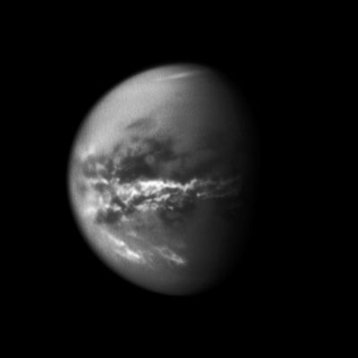 Titan's Equatorial Clouds 
Caption NASA:"NASA's Cassini Spacecraft chronicles the change of Seasons as it captures Clouds concentrated near the Equator of Saturn's largest moon, Titan.

Methane Clouds in the Troposphere, the lowest part of the Atmosphere, appear white here and are mostly near Titan's Equator. The darkest areas are Surface Features that have a low albedo, meaning they do not reflect much light. 
Cassini observations of Clouds like these provide evidence of a seasonal shift of Titan's weather systems to low latitudes following the August 2009 Equinox in the Saturnian System (during Equinox, the Sun lies directly over the Equator (see PIA11667 to learn how the Sun's illumination of the Saturnian System changed during the Equinox transition to Spring in the Northern Hemispheres and to Fall in the Southern Hemispheres of the Planet and its moons).

In 2004, during Titan's late Southern Summer, extensive Cloud Systems were common in Titan's South Polar Region (see PIA06110, PIA06124 and PIA06241). Since 2005, Southern Polar Systems have been observed infrequently, and one year after the Equinox, extensive near-equatorial Clouds have been seen. 

This image was taken on Oct. 18, 2010, a little more than one Earth year after the Saturnian Equinox, which happens once in roughly 15 Earth years.
The cloud patterns observed from late Southern Summer to early Southern Fall on Titan suggest that Titan's Global Atmospheric Circulation is influenced by both the Atmosphere and the Surface. The temperature of the Surface responds more rapidly to changes in illumination than does the thick Atmosphere. Outbreaks such as the Clouds seen here may be the Titan equivalent of what creates the Earth's tropical rainforest climates, even though the delayed reaction to the change of seasons and the apparently sudden shift is more reminiscent of the behavior over Earth's tropical oceans than over tropical land areas.

A few clouds can be seen in Titan's Southern Latitudes here and some clouds are also visible in the high Northern Latitudes.

This view looks toward the Saturn-facing side of Titan (approx. 5150 Km or 3198,15 miles across). North is up. The image appears slightly grainy because it was re-projected to a scale of about 6 Km (3,726 miles) per pixel. Scale in the original image was approx. 15 Km (9,315 miles) per pixel. 
This view consists of an average of three images taken using a filter sensitive to Near-InfraRed Light centered at 938 nanometers, which allows for detection of Titan's Surface and Lower Atmosphere, plus an image taken using a filter sensitive to Visible Light centered at 619 nanometers.

The images were taken with the Cassini spacecraft's narrow-angle camera at a distance of approx. 2,5 MKM (1.552.500 MMs) from Titan and at a Sun-Titan-Spacecraft, or Phase, Angle of 56°".
Parole chiave: Titan