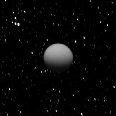 Titan in Eclipse
Caption NASA:"The Cassini spacecraft captured this image of a dimly lit Titan as Saturn's largest moon was eclipsed by the Planet. 
This view looks up toward the South Pole of Titan which lies on the Terminator about a quarter of the way inward from the right of the visible disk. Lit terrain seen here is on the Saturn-facing side of Titan. In Saturn's shadow, the Southern Hemisphere of Titan is lit by two sources: sunlight scattered through the Planet's Rings and refracted sunlight passing through the edge of Saturn's Atmosphere.
Stars in this image are smeared by the long camera exposure time of 560" needed to capture the faint light on Titan. The image was taken in Visible Light with the Cassini Spacecraft wide-angle camera on May 7, 2009. The view was acquired at a distance of approx. 667.000 Km (about 414.000 miles) from Titan and at a Phase Angle of 58°.
Image scale is roughly 40 Km (about 25 miles) per pixel".
Parole chiave: Saturn's Moon - Titan