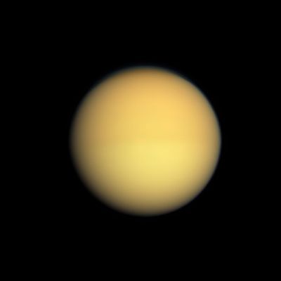 Seasonal Changes on Titan (Natural Colors; credits: NASA/JPL/Space Science Institute)
Seasonal changes in the Atmosphere of Saturn's largest moon are captured in this Natural Color image, which shows Titan with a slightly darker top half and a slightly lighter bottom half. 
Titan's Atmosphere has a seasonal hemispheric dichotomy, and this image was taken shortly after Saturn's August 2009 Equinox. 
Images taken using red, green and blue spectral filters were combined to create this Natural Color view. 
Scientists have found that the Winter Hemisphere typically appears to have more high-altitude haze, making it darker at shorter wavelengths (UltraViolet through blue) and brighter at InfraRed wavelengths. 

The switch between dark and bright occurred over the course of a year or two around the last Equinox. Scientists are studying the mechanism responsible for this change, and will monitor the dark-light difference as it flip-flops now that the 2009 Equinox has signaled the coming of Spring and then Summer in the Northern Hemisphere. 
Although this hemispheric boundary appears to run directly East-West near the Equator, its position is not level with latitude and is actually offset from the Equator by about 10° of Latitude. 
This view looks toward the Saturn-facing side of Titan. North on Titan is up. 

The images were obtained with the Cassini Spacecraft wide-angle camera on Aug. 25, 2009 at a distance of approx. 174.000 Km (such as about 108.000 miles) from Titan. 
Image scale is roughly 10 Km (a little more than 6 miles) per pixel.
Parole chiave: Titan