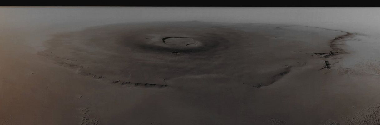 Olympus Mons (Absolute Natural Colors; credits for the additional process. and color: Dr Paolo C. Fienga - Lunexit Team)
Caption originale: "This is a red camera wide angle view of the Giant Martian Volcano, Olympus Mons, acquired by the Mars Global Surveyor (MGS) Mars Orbiter Camera (MOC). The Volcano is large enough to cover much of the state of New Mexico. This view was taken looking West toward the Sunward Limb of the Planet. The limb is the horizon to the left; the dark band is outer space. Sunlight illuminates this scene from the lower left". 
Parole chiave: Mars from orbit - Volcanoes - Olympus Mons
