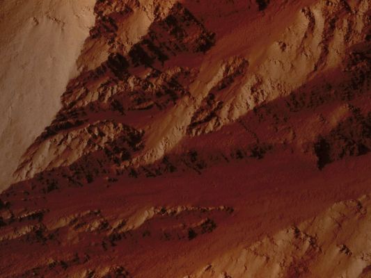 Olympus' Edge (Extremely Enhanced Absolute Natural Colors; credits for the additional process. and color.: Dr Paolo C. Fienga - Lunexit Team)
This image covers the Northern Edge of the largest Volcano of the Solar System: Olympus Mons. 

The margin of Olympus Mons is defined by a massive Cliff which is several kilometers tall. At this location, the Cliff is nearly 7 Km (about 23.000 feet) tall. 
The Cliff exposes the guts of the volcano, revealing interbedded hard and soft layers. The hard layers are Lava and the soft layers may be Dust (from large Dust Storms) or Volcanic Ash. 

The High Resolution Imaging Science Experiment (HiRISE) camera on NASA's Mars Reconnaissance Orbiter recorded this image on March 2, 2010.
Most scientists think the the Cliffs formed by Landslides. This collapse is driven by the weight of the huge volcano exceeding the strength of the rocks it is built of. 

This image covers a swath of ground about 1 Km (such as approx. two-thirds of a mile) wide. It is a portion of HiRISE observation ESP_016886_2030, which is centered at 22,95° North Lat. and 224,76° East Long. The season on Mars is Northern-Hemisphere Spring. 
Other image products from this observation are available at http://hirise.lpl.arizona.edu/ESP_016886_2030.
Parole chiave: Mars from orbit - Volcanoes - Olympus Mons