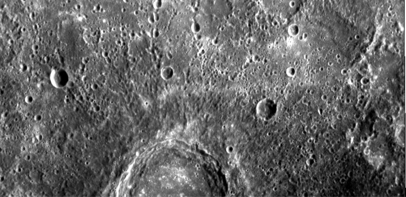 Fresh Primary Impact Crater and Secondary Craters (HR)
On January 14, 2008, NASA’s MESSENGER spacecraft observed about half of the hemisphere not seen by Mariner 10. This image shows part of a large, fresh crater with secondary crater chains located near Mercury’s Equator on the side of the Planet newly imaged by MESSENGER. 
Large, flat-floored craters show terraced rims from post-impact collapse of their newly formed walls. The hundreds of secondary impactors that are excavated from the Planet’s surface by an incoming object, create long, linear crater chains radial to the main crater. 
These chains, in addition to the rest of the ejecta blanket, create the complicated, hilly terrain surrounding the primary crater in the image. By counting craters that have formed since the impact event, the age of the crater can be estimated. 
This count can then be compared with a similar count for the crater floor to determine whether any material has partially filled the crater since its formation. With their large size and production of abundant secondary craters, these flat-floored craters both illuminate and confound the study of the geological history of Mercury. 
Parole chiave: Mercury Fly-By